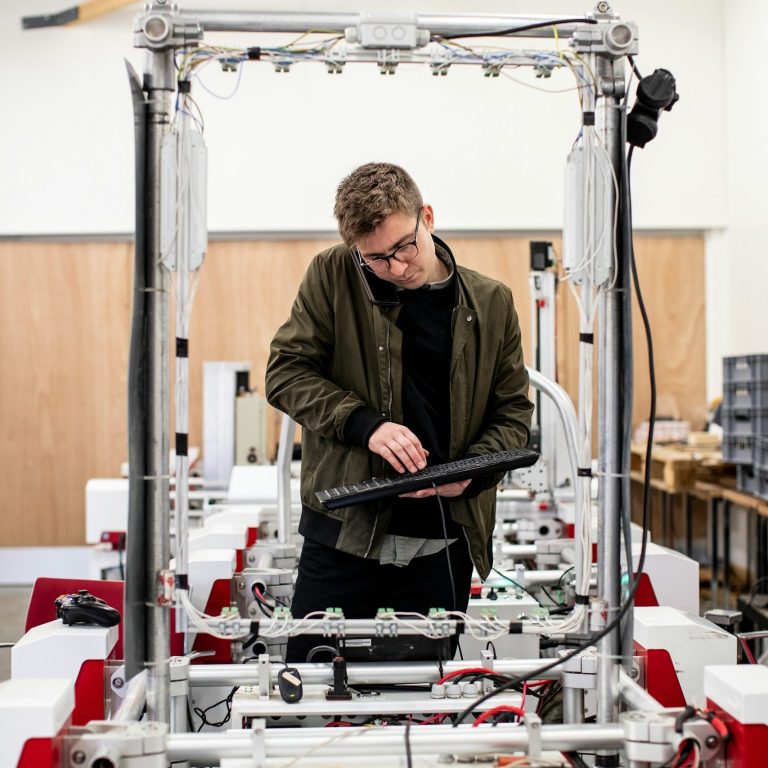 engineering Ein Mann tüftelt an einer Maschine